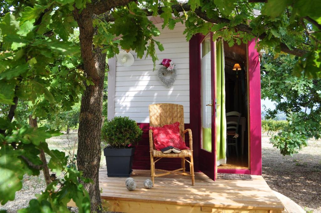 una silla sentada en el porche de una casa en La roulotte Chic et Boheme, en Mazan