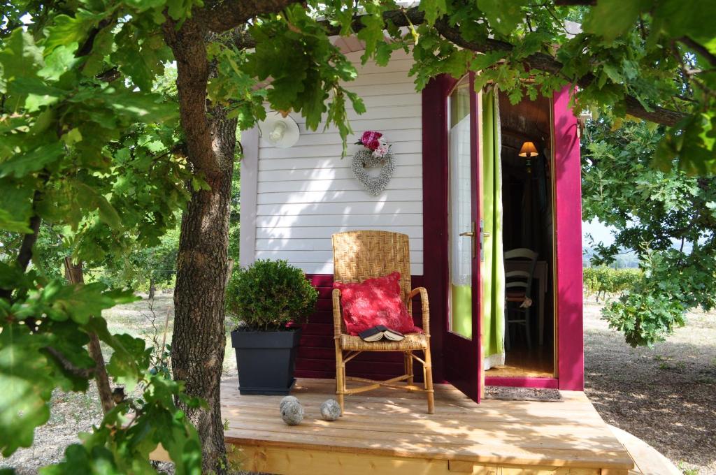 una sedia seduta sul portico di una casa di La roulotte Chic et Boheme a Mazan