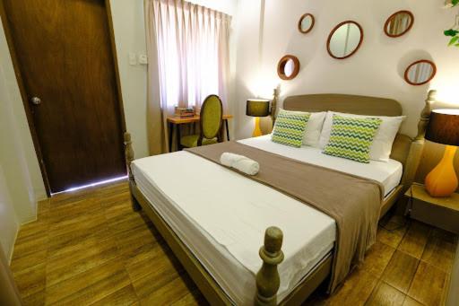 a bedroom with a bed and mirrors on the wall at The Weekend Farmer in Alfonso