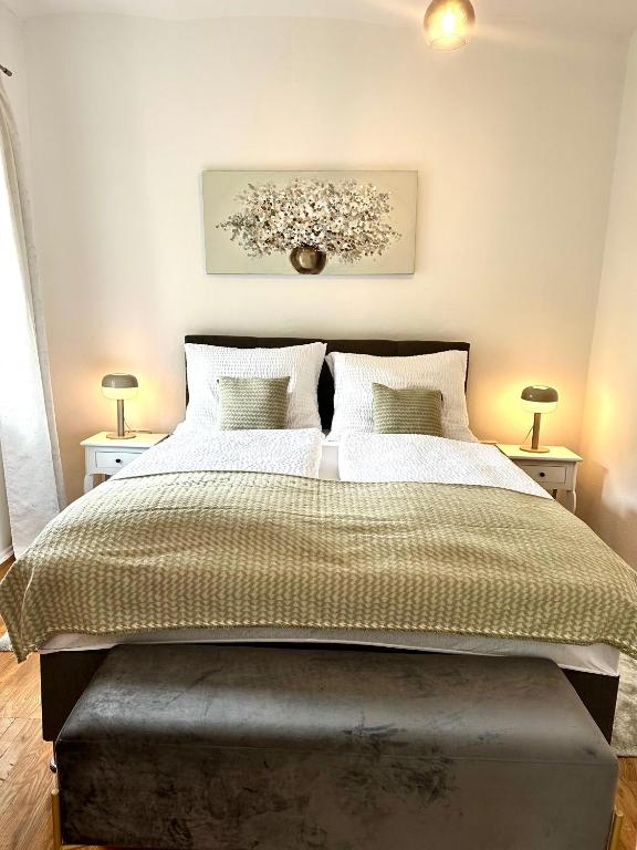 a bedroom with a large bed with two lamps at Ferienwohnung Gänseblümchen in Feistritz an der Gail