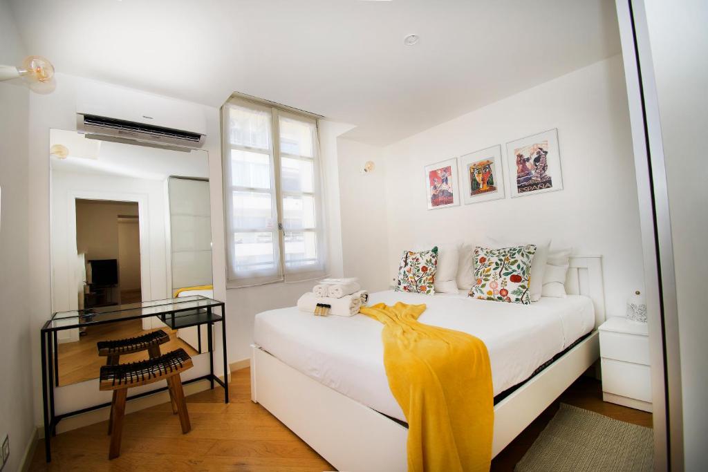 a white bedroom with a bed and a mirror at Princes Victoria Standing Presta in Cannes