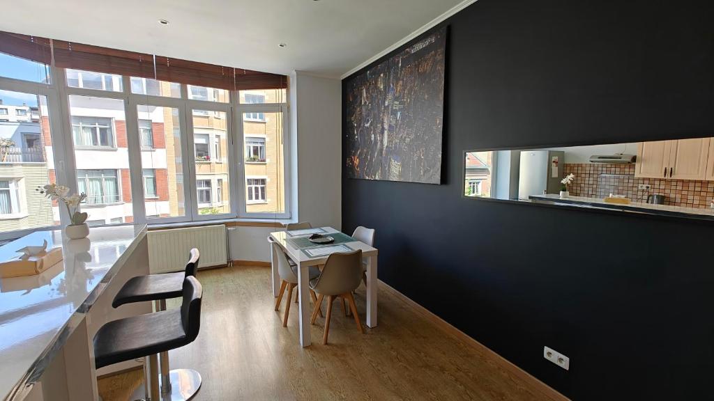 une salle à manger avec une table et des chaises et une fenêtre dans l'établissement Suite Diamant - Chic & Lumineux, à Bruxelles
