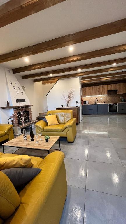 a living room with yellow couches and a kitchen at Jako doma in Ivaň
