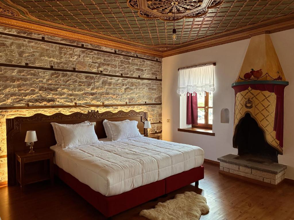 a bedroom with a bed and a stone wall at Kalemi Twin Boutique Hotel in Gjirokastër