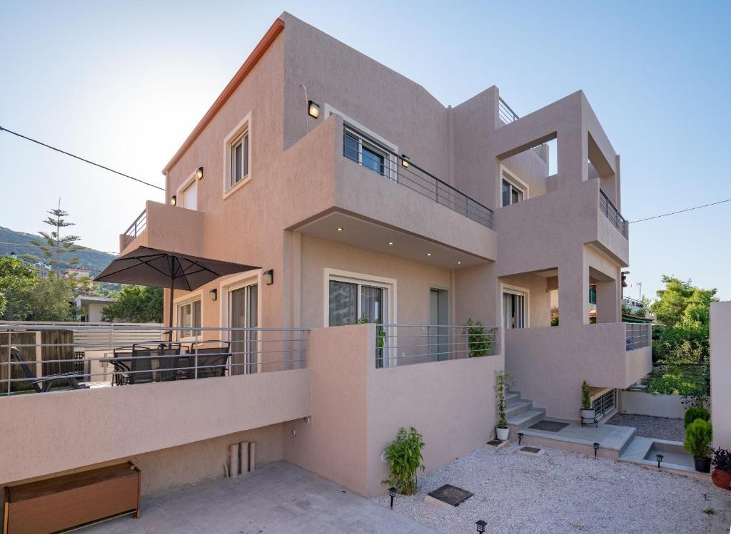 una casa grande con balcón con patio en Villa Mareluna by Traser, en Artemida