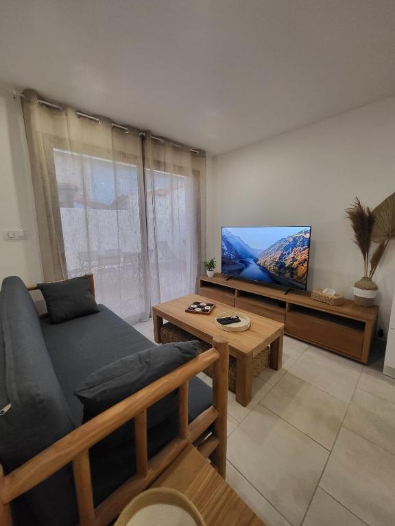 un salon avec un canapé et une télévision à écran plat dans l'établissement Ubud, à Sainte-Marie-la-Mer