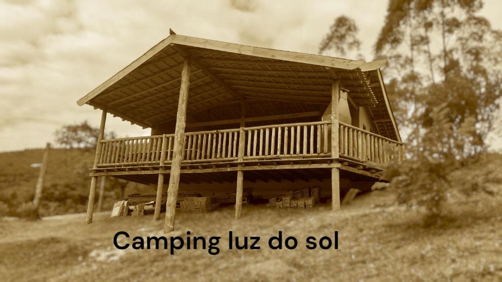 a house with a deck on top of a hill at Camping luz do sol in Aiuruoca