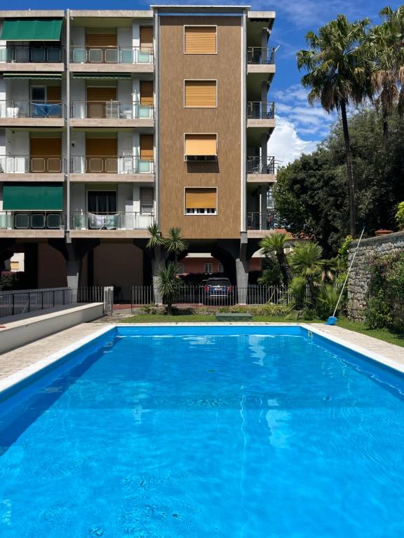 a large blue swimming pool in front of a building at affascinante bilocale con piscina in Bordighera