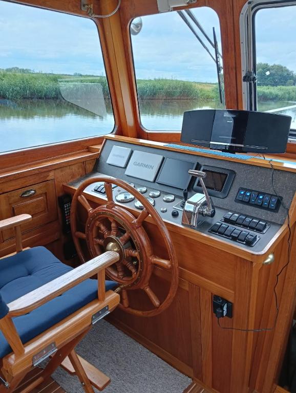a dashboard of a boat with a steering wheel at Deluxe romantic boat in Hoogeveen