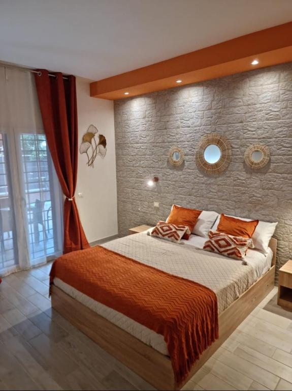 a bedroom with a large bed and a brick wall at Eden Bay Vacation Home in Ladispoli