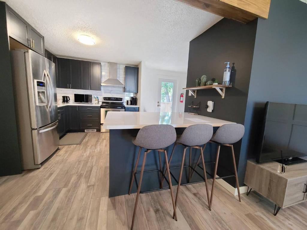 a kitchen with a counter and two bar stools at Spacious 3-Bedroom Home. in Regina