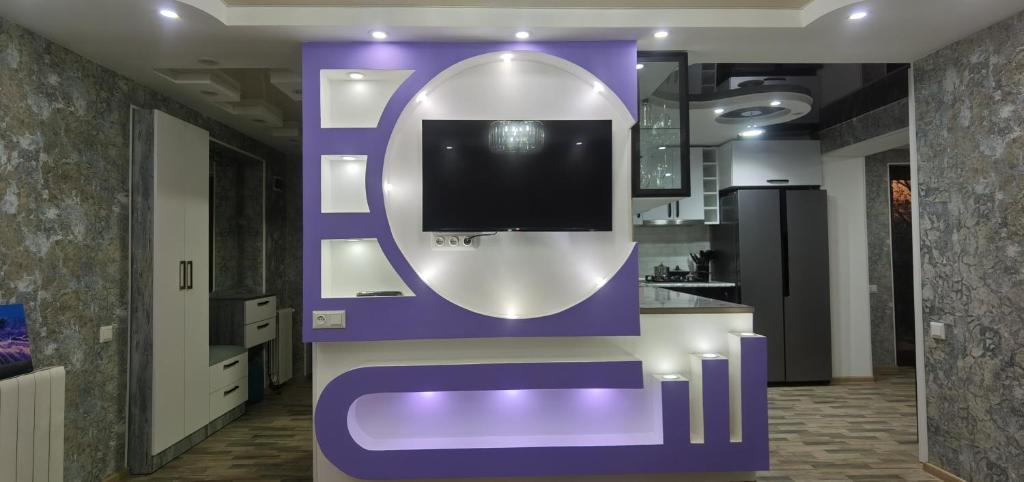 fioletowa wystawa z telewizorem na ścianie w obiekcie TEMO'S APARTAMENT IN KUTAISI w Kutaisi