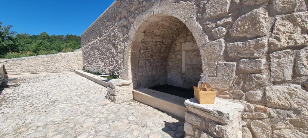 a stone building with a stone wall with a door at la dimora di Fonte Vecchia in San Pio delle Camere