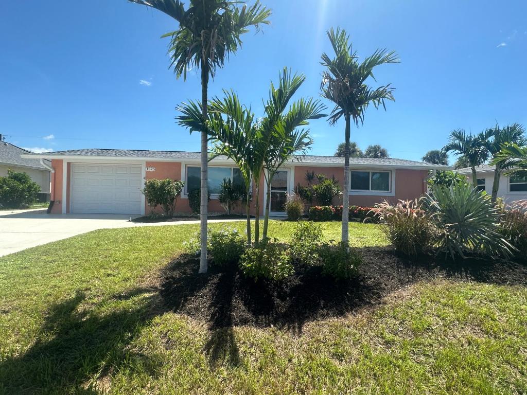 a house with palm trees in the front yard at Charming 3-bedroom House In Delightful Englewood in Englewood