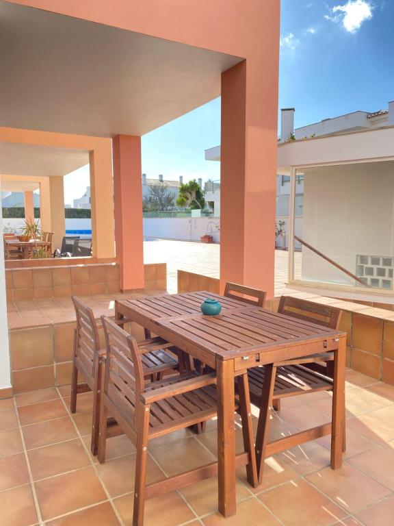 ein Holztisch und Stühle auf einer Terrasse in der Unterkunft Porto de Abrigo in Burgau