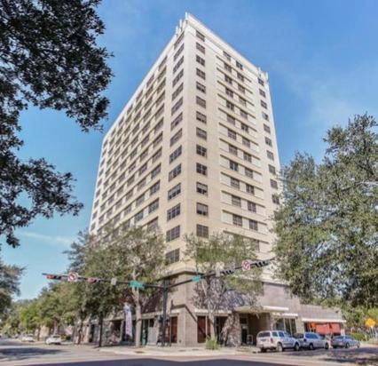 a tall white building with cars parked in front of it at One Bedroom Downtown in Jacksonville