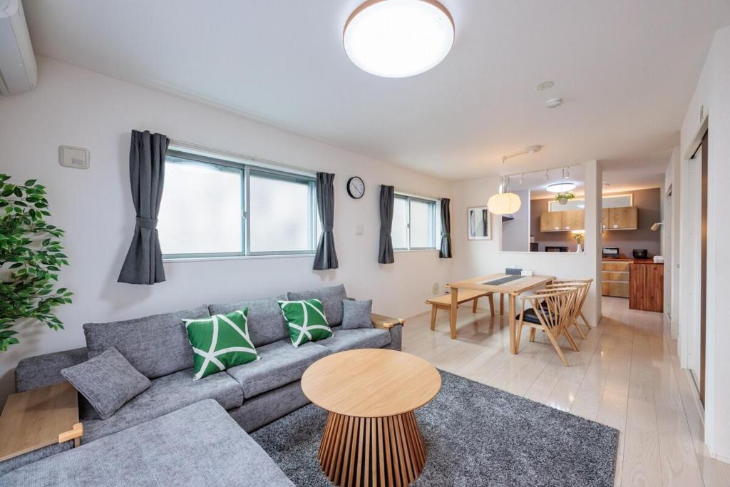 een woonkamer met een bank en een tafel bij House FORMOSA熱田 in Nagoya
