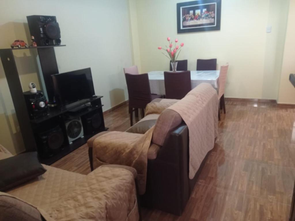 een woonkamer met een tafel en wat stoelen bij Oceánica Lodge in Ilo