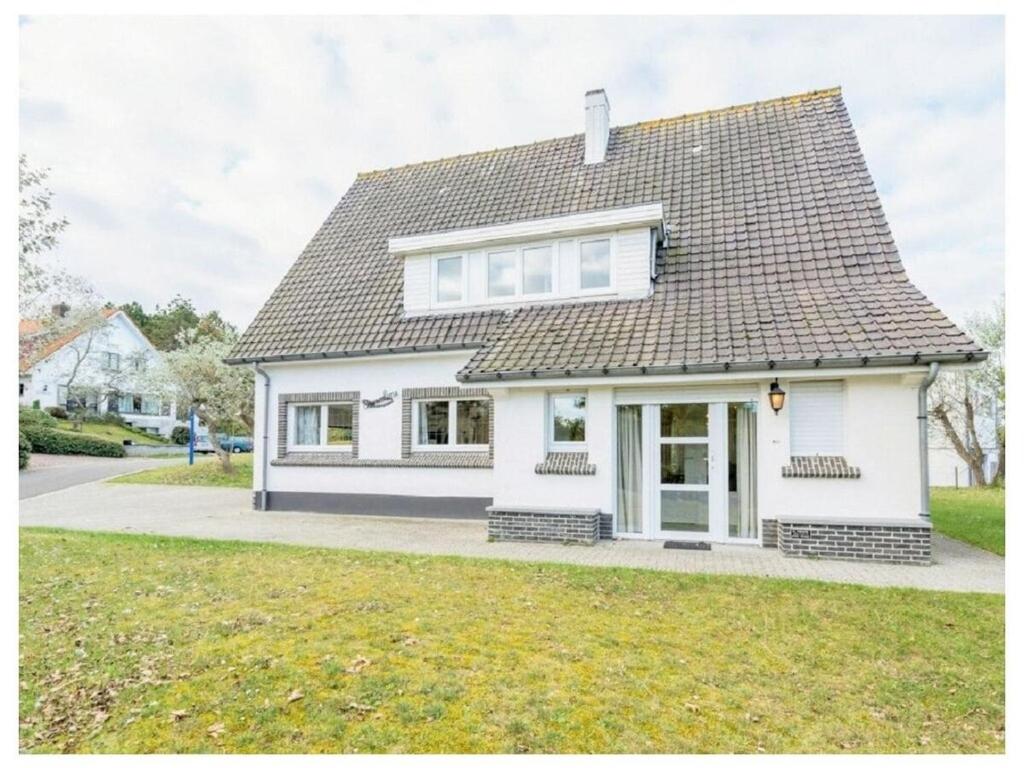 a white house with a gray roof at Holiday home in De Panne with barbecue in De Panne