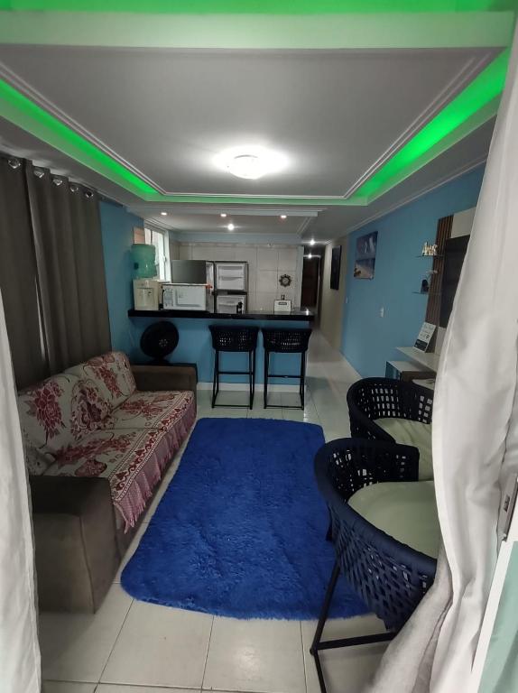a living room with a couch and a blue rug at Apto pé na Areia 2 in Ilha do Frade