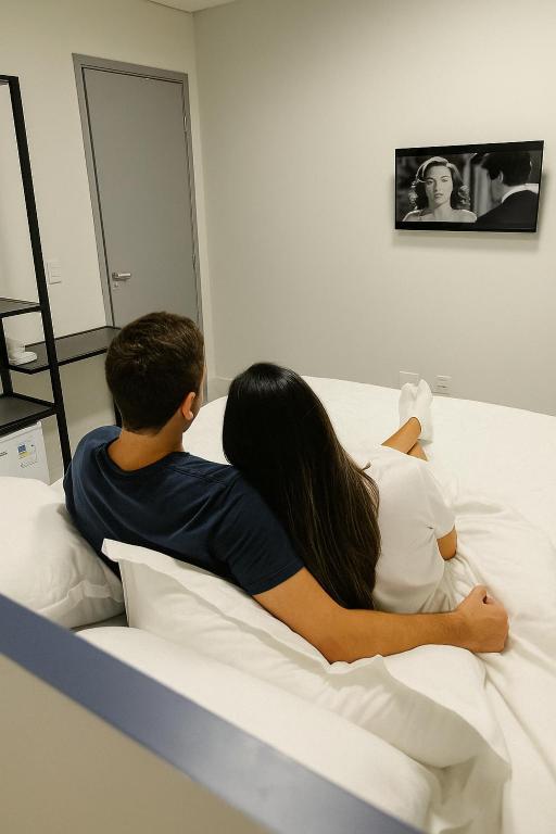 a man and a woman laying on a bed at Hotel Soberano Brasília l SLEEP HOTÉIS in Taguatinga
