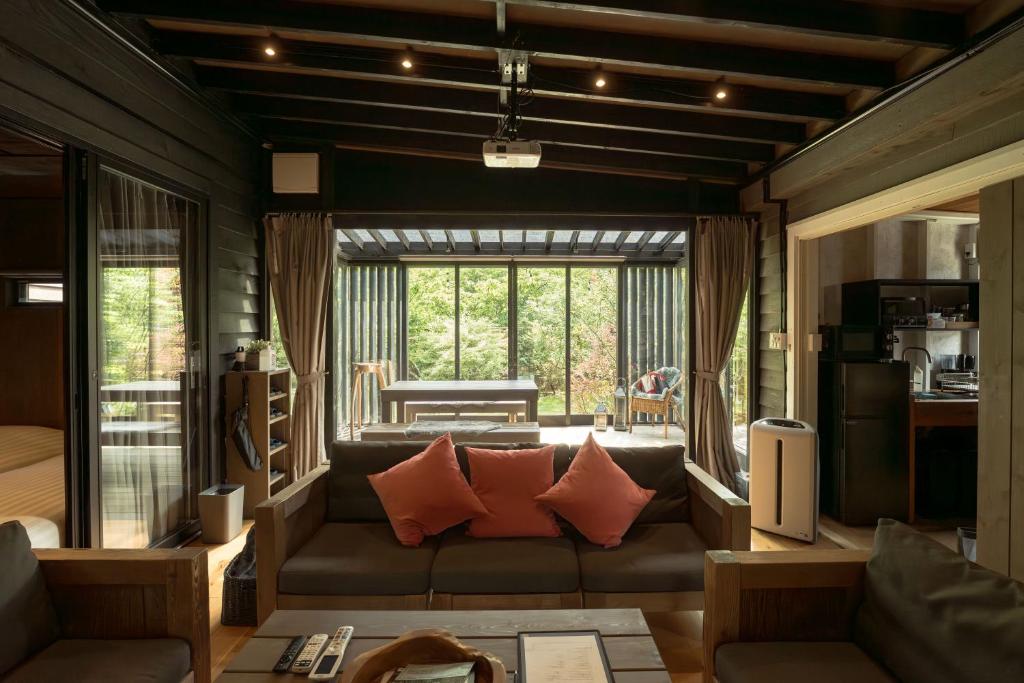 un soggiorno con un divano e una grande finestra di Tiny Base The River HOUSE & TRAILER a Kawazu