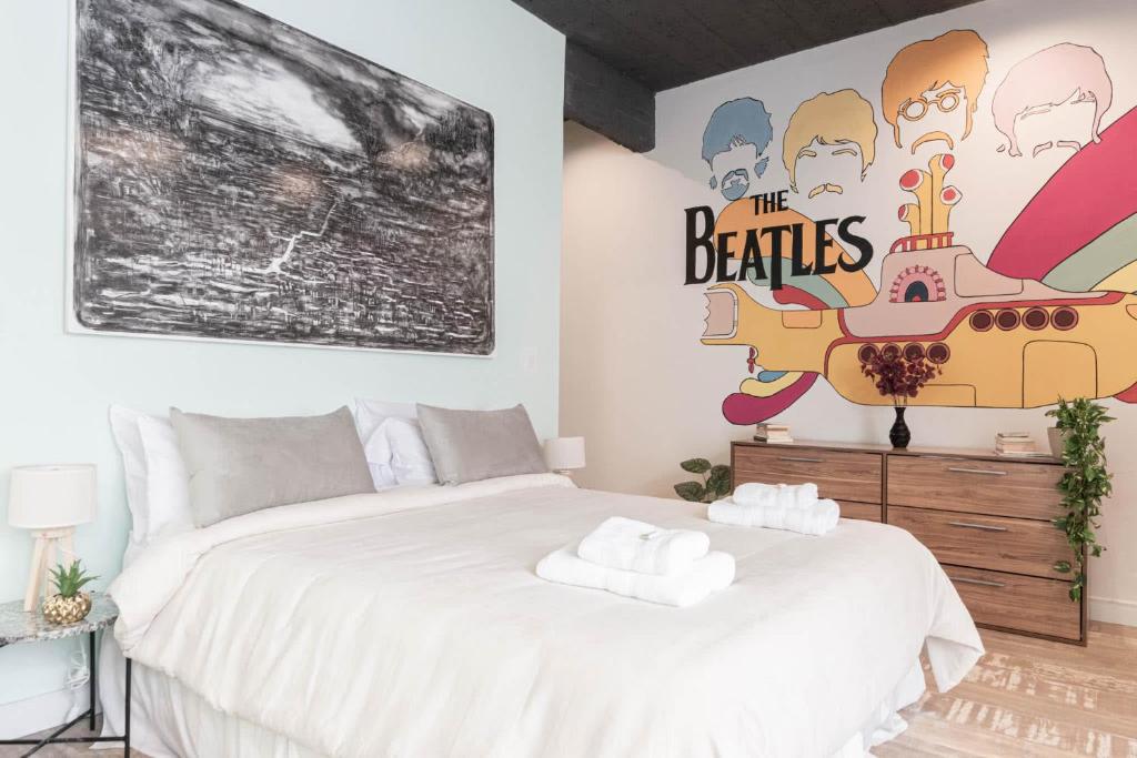 a bedroom with a white bed and a large painting at Fliphaus ChicHaus 9 Lux Units 36 pax Daily Housekeeping! in Buenos Aires