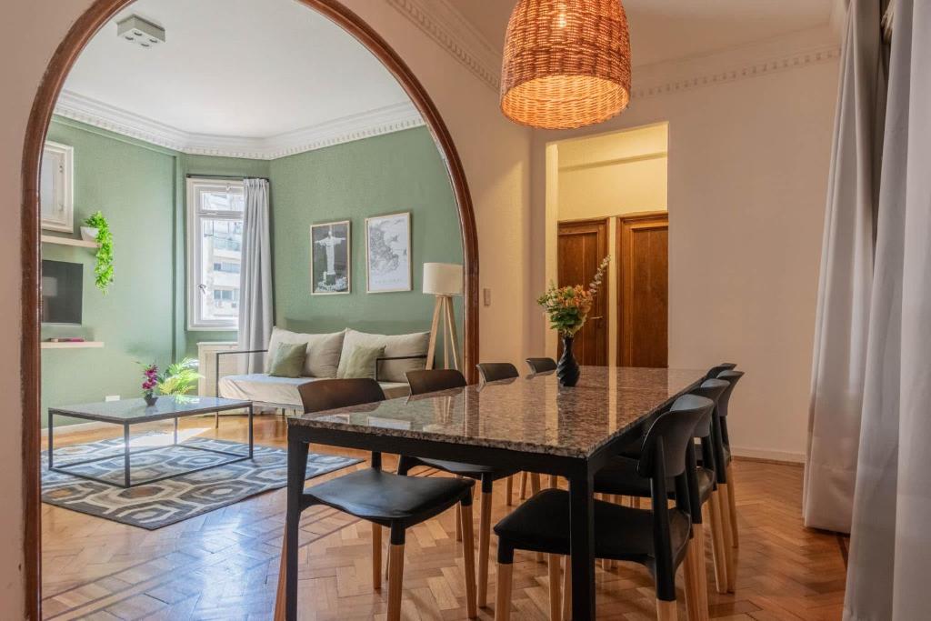 a dining room with a table and chairs and a couch at Fliphaus Maipu 800 - 2 Bd Calle Florida in Buenos Aires