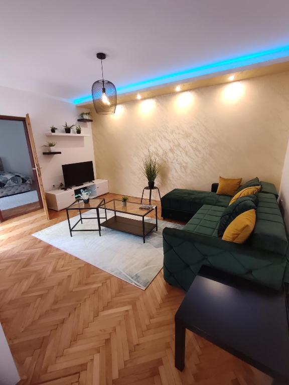 a living room with a green couch and a table at Apartman Stay 23 with Free parking in Smederevo