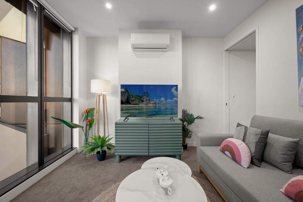 メルボルンにあるCosy CBD Park Views Retreatのソファとテーブルのあるリビングルーム