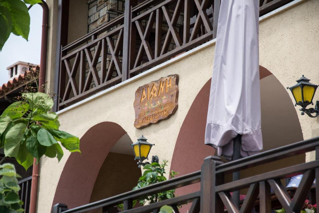 una señal en el lateral de un edificio con una sombrilla en Dione Apartments, en Ouranoupoli