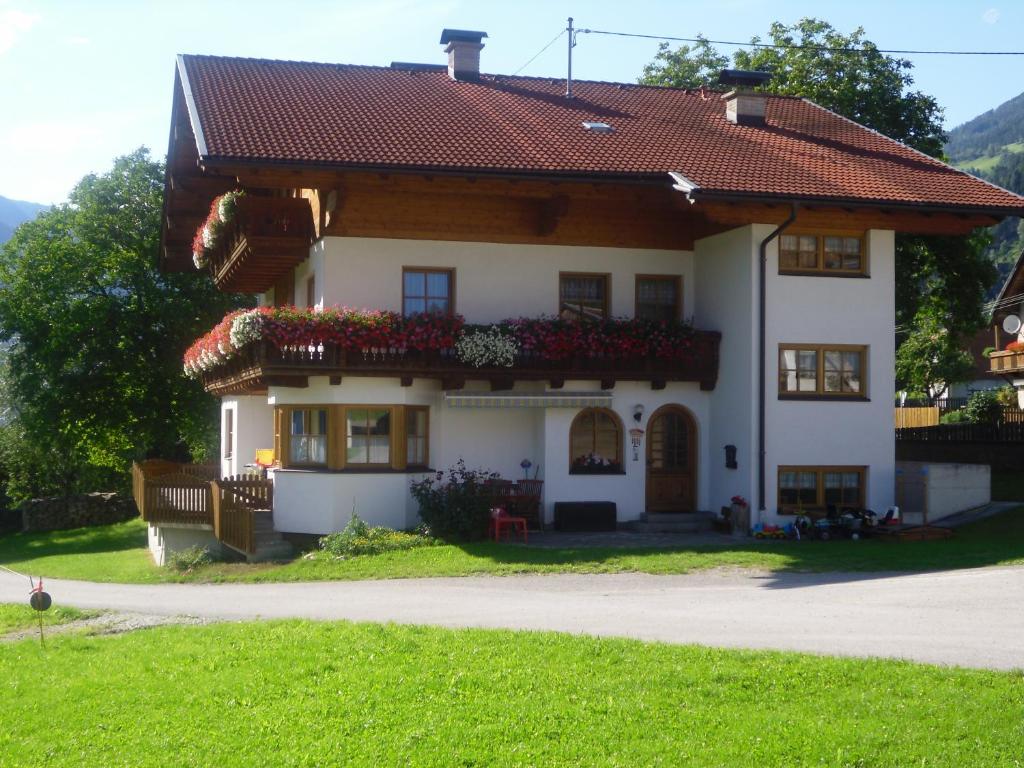 ein weißes Haus mit Blumen auf der Seite in der Unterkunft Nagelehof in Ainet