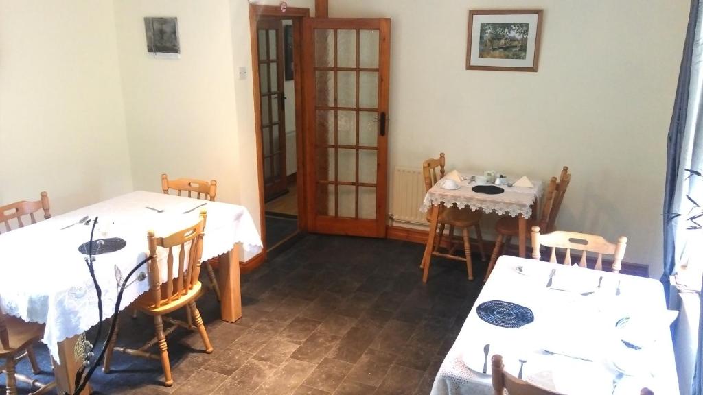 a dining room with two tables and chairs at Gortnaboul House in Kilgarvan