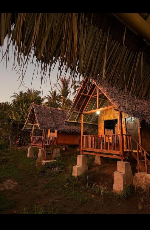 a house with a thatched roof and a porch at Pondok Sedi Bungalow in Labuhancari