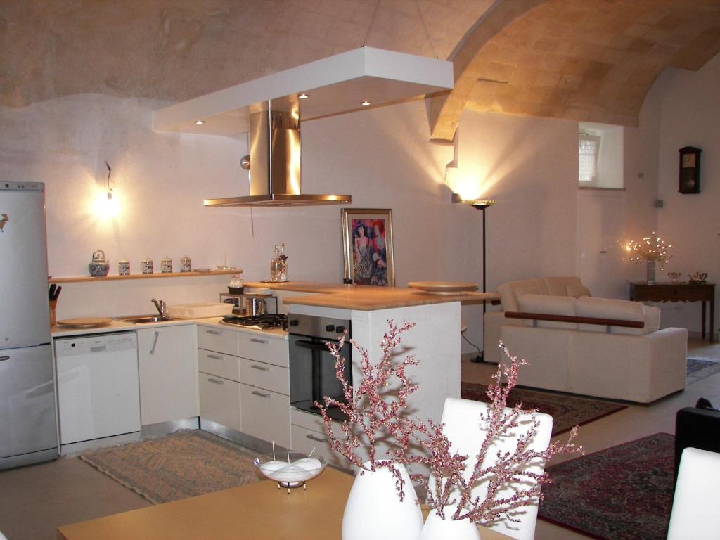 een keuken en een woonkamer met een tafel bij Corte San Biagio,29 in Matera