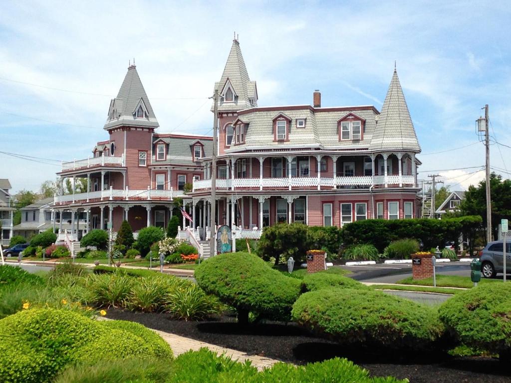 a large pink house with two towers on a street at Angel of the Sea Bed and Breakfast in Cape May