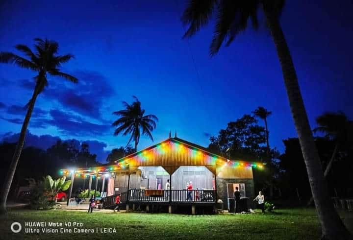 a marquee lit up at night with palm trees at Impian May Homestay 2 Private Pool in Kampung Raja
