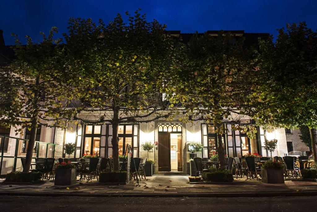 a building with tables and chairs in front of it at In den Roden Leeuw van Limburg in Wittem