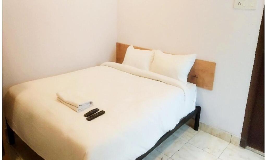 una camera da letto con un letto bianco con due libri sopra di Hotel Ganesh Pashu-Patinath inn Gorakhpur AC OR NON AC ROOM UP a Gorakhpur