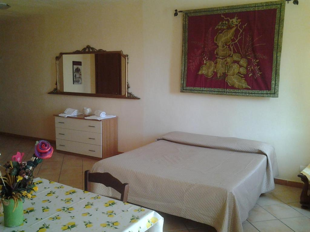 ポルト・エンペードクレにあるAppartamento Sergioのベッドルーム(ベッド1台、テーブル、鏡付)