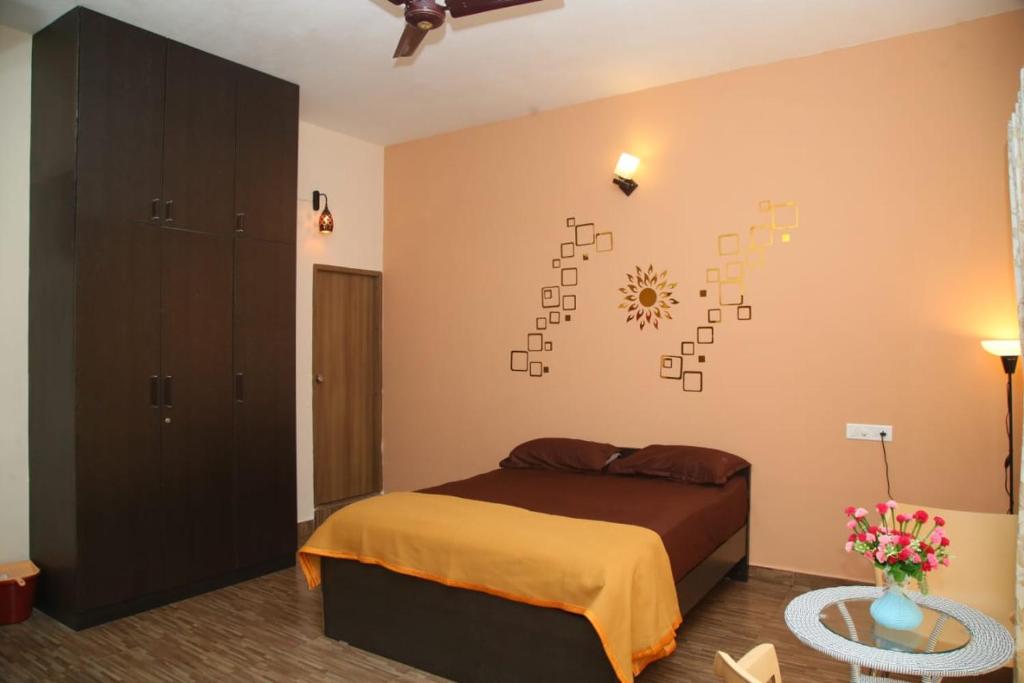 a bedroom with a bed and a clock on the wall at Beachside Bliss - Villa 32 in Kilpettai