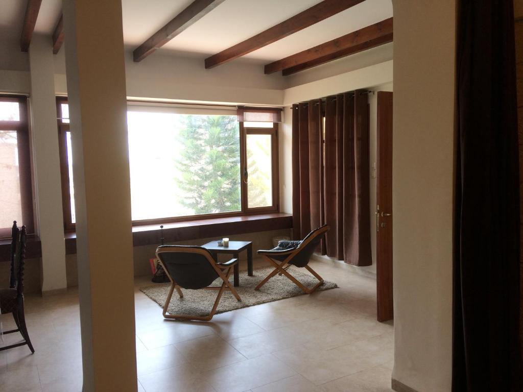un soggiorno con sedie, tavolo e finestra di Miriam Short Term Rental a Nazareth