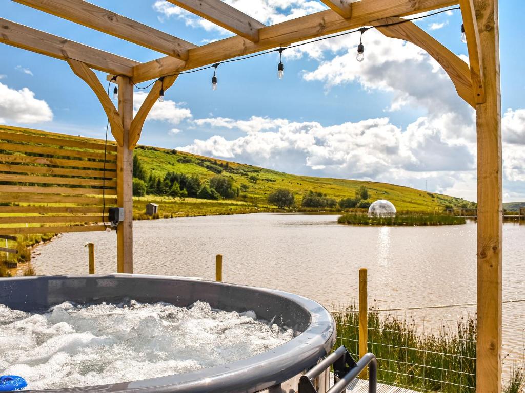 a hot tub in front of a body of water at The Rose in Rhondda