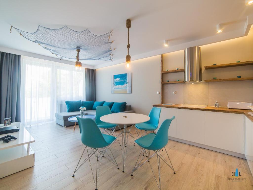 a kitchen and living room with a table and chairs at 3L Apartments Bliżej Morza in Kołobrzeg