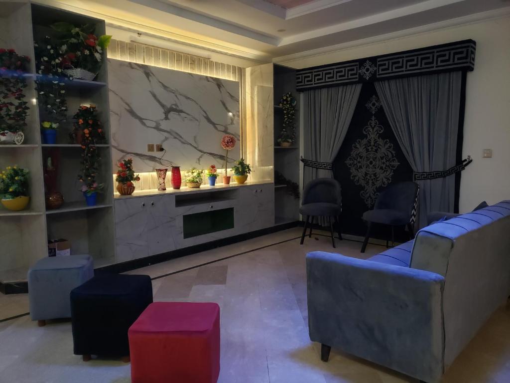 una sala de estar con 2 sillas y una pantalla grande en Guest Ghar Islamabad, en Islamabad