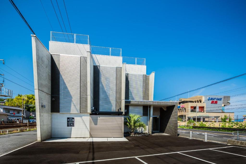 a building with a parking lot in front of it at BOND COMFORT HOTEL MIYAJIMAGUCHI - Vacation STAY 79227v in Hatsukaichi