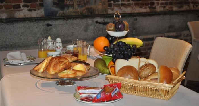 una mesa con un montón de pan y fruta en ella en Onsemhoeve, en Dilbeek