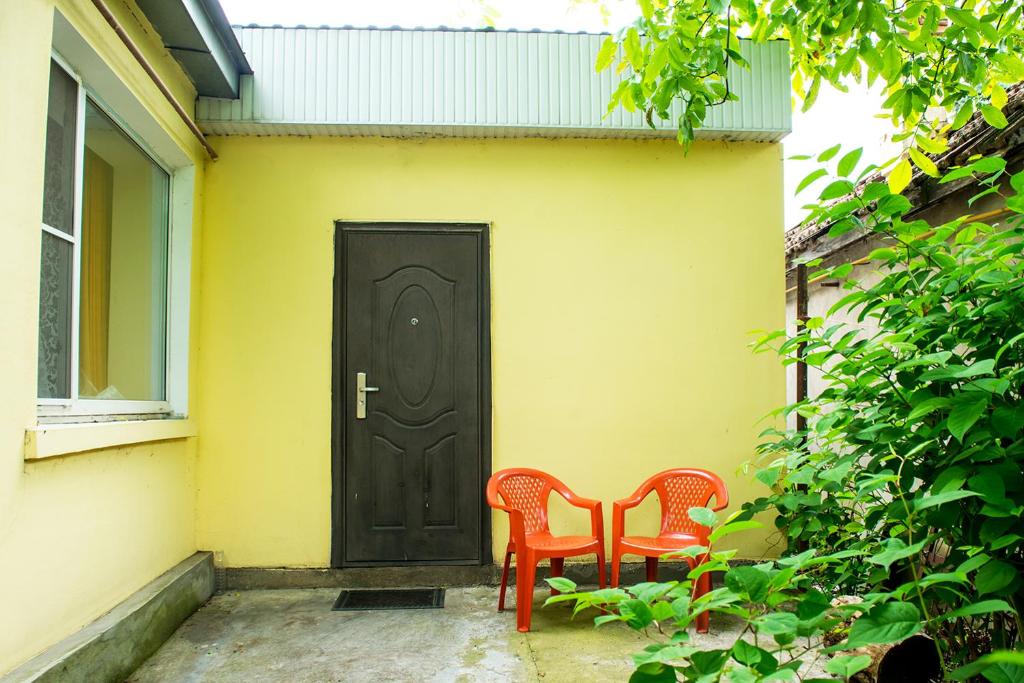 ピャチゴルスクにあるApartment Na Parkovoyの黒いドアの前に座るオレンジ色の椅子2脚