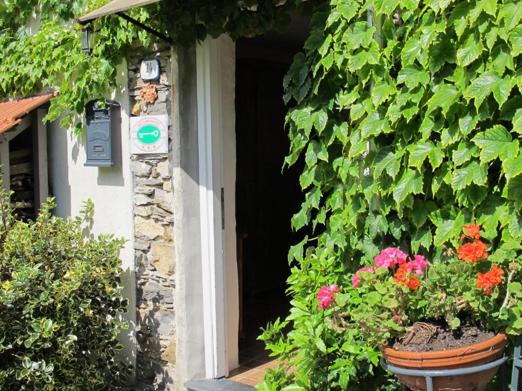 a house with flowers in front of a door at B&B Sul Cammino in Dolcedo