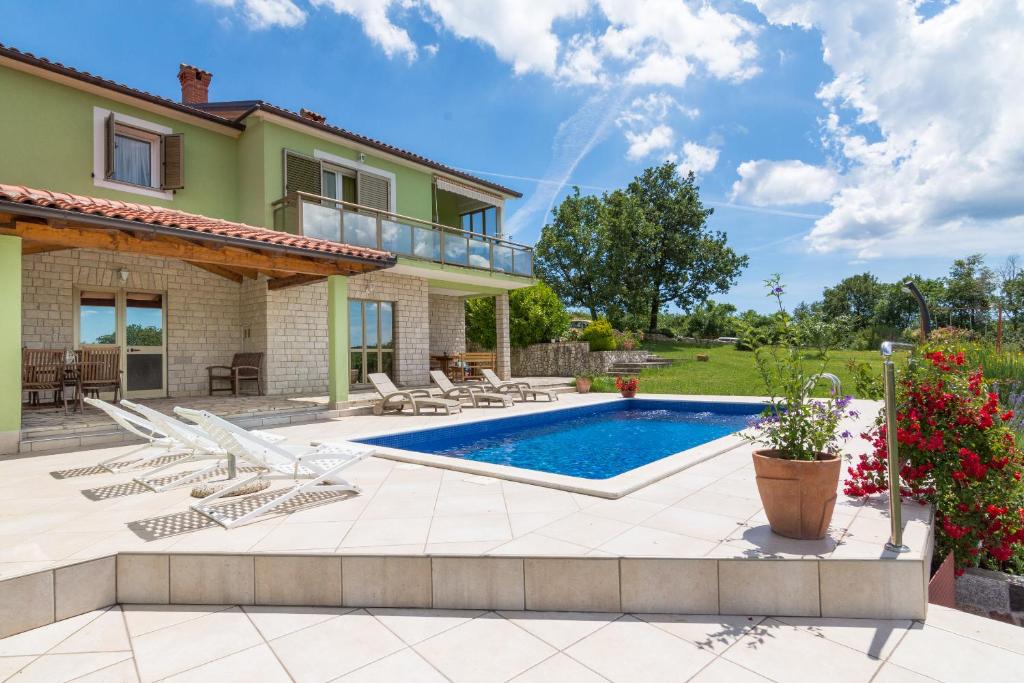 a house with a swimming pool and a patio at Apartments Cekada in Labin